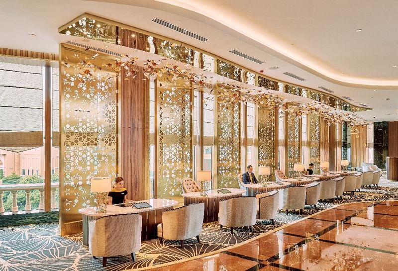 Elegant Sunway Resort lobby featuring gold-accented screens, sleek check-in desks, and friendly front desk staff