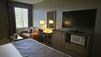 Couch with working table and Flat tv- Monte Carlo Inn Airport Su