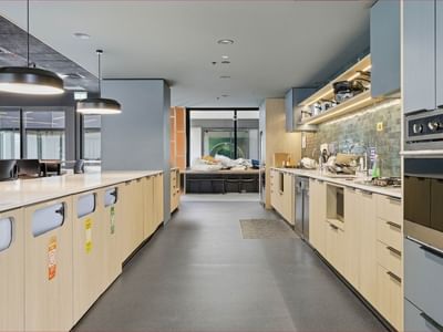 Modern kitchen area with appliances, cabinetry, and seating area at Mayoral Drive Student Accommodation.