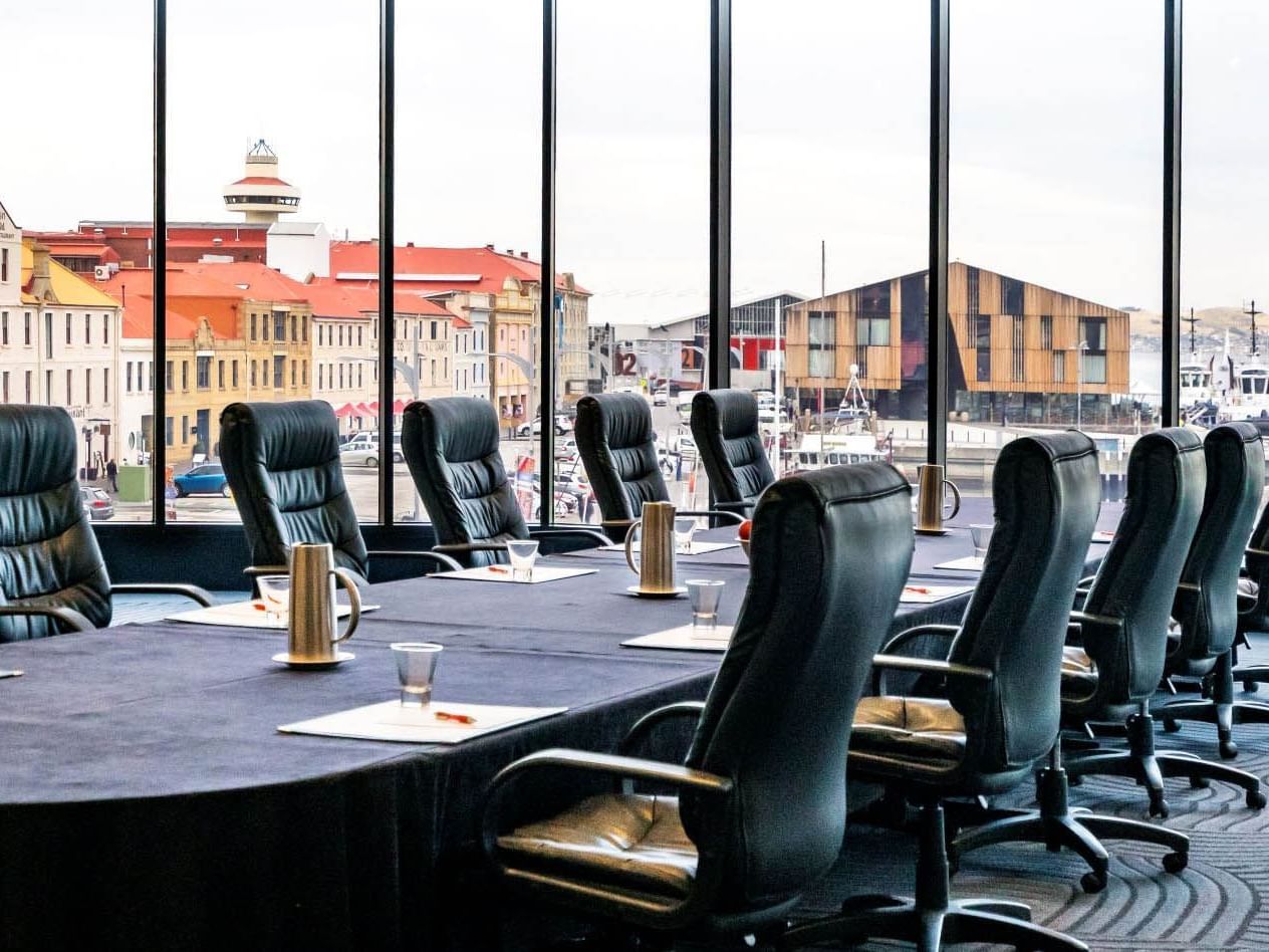 Side view of Harbour View Room Two featuring T shape set-up with black chairs at Hotel Grand Chancellor Hobart