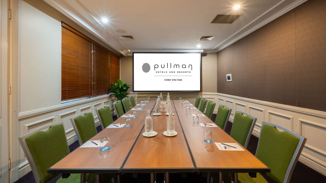 Boardroom set-up with projector screen in Dalley Room at Pullman Sydney Hyde Park