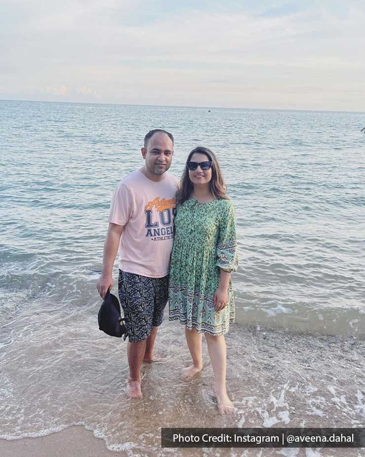 couple posing for a picture with sparkling ocean in the background