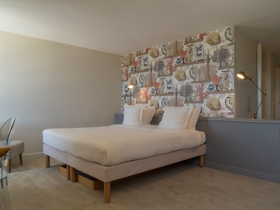 Queen bed in a bedroom at Hotel de la Mer