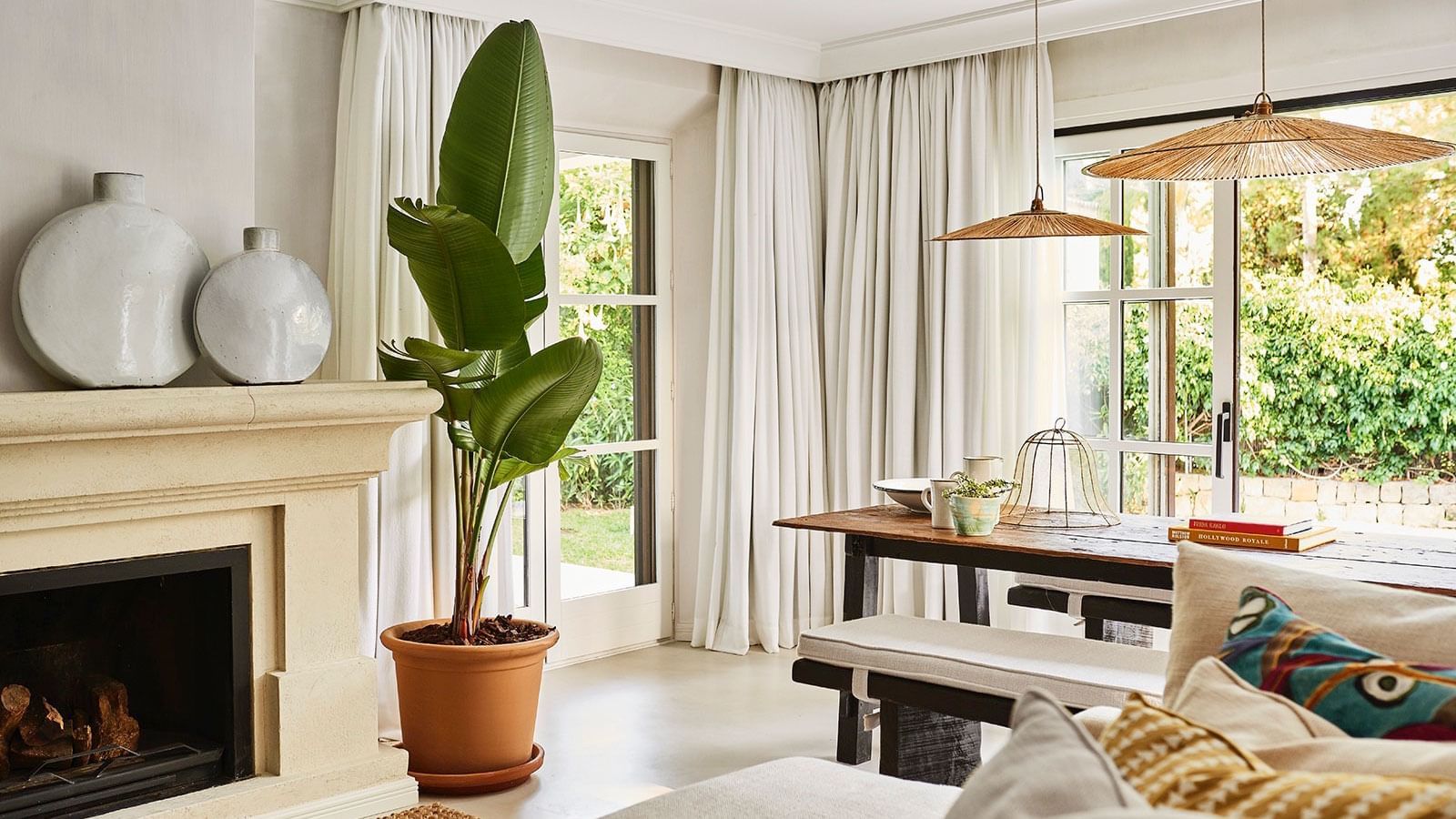Four-bedroom villa with a large potted plant placed by a fireplace and dining table at Marbella Club