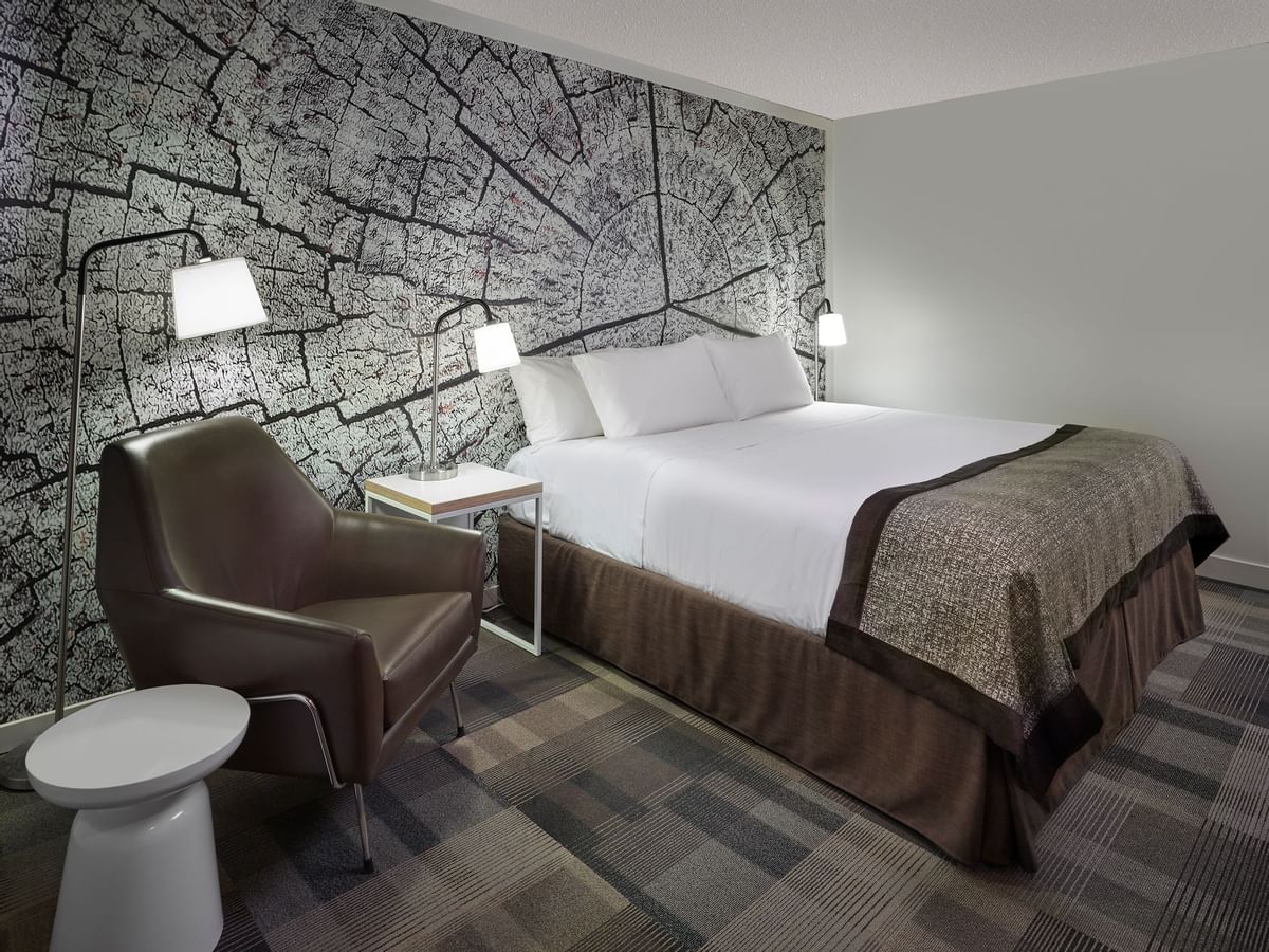 Bed in hotel room with artwork of tree trunk