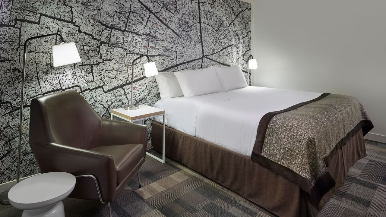 Bed in hotel room with artwork of tree trunk