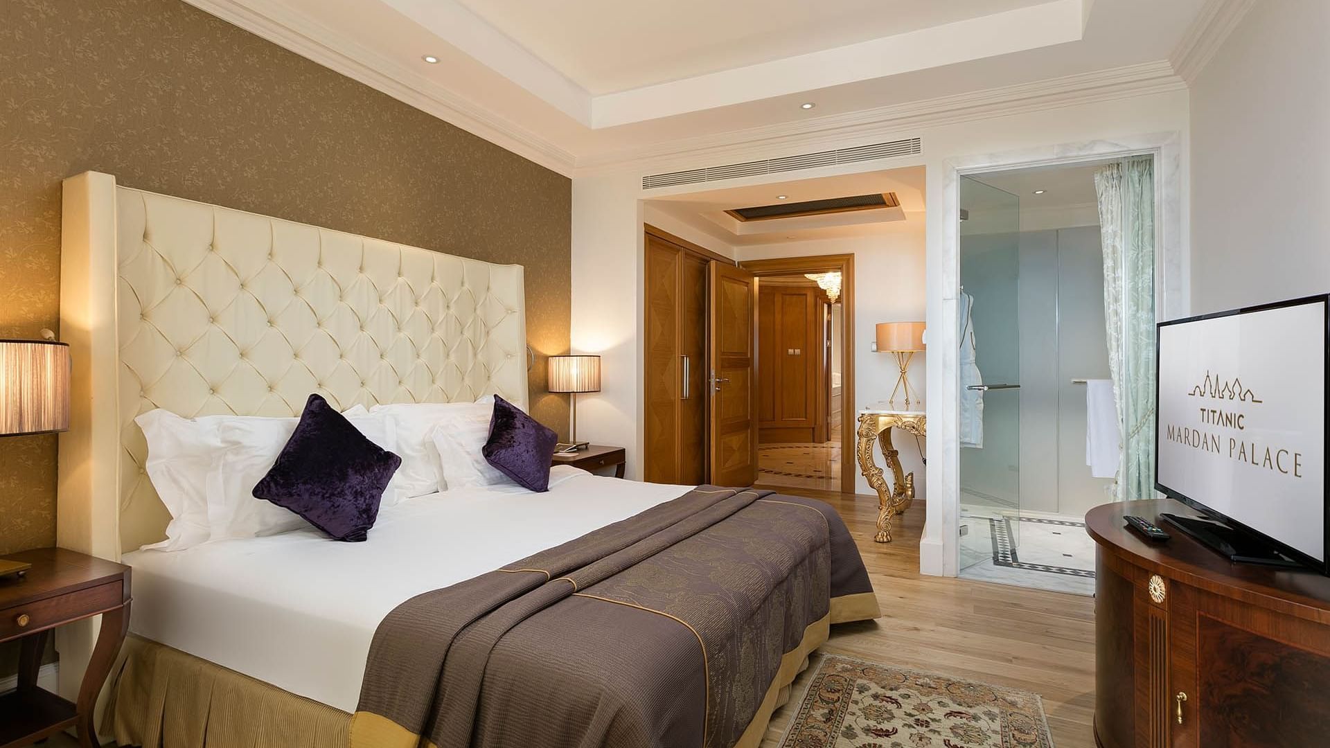Удобная кровать и телевизор в президентском люксе отеля Titanic Mardan Palace