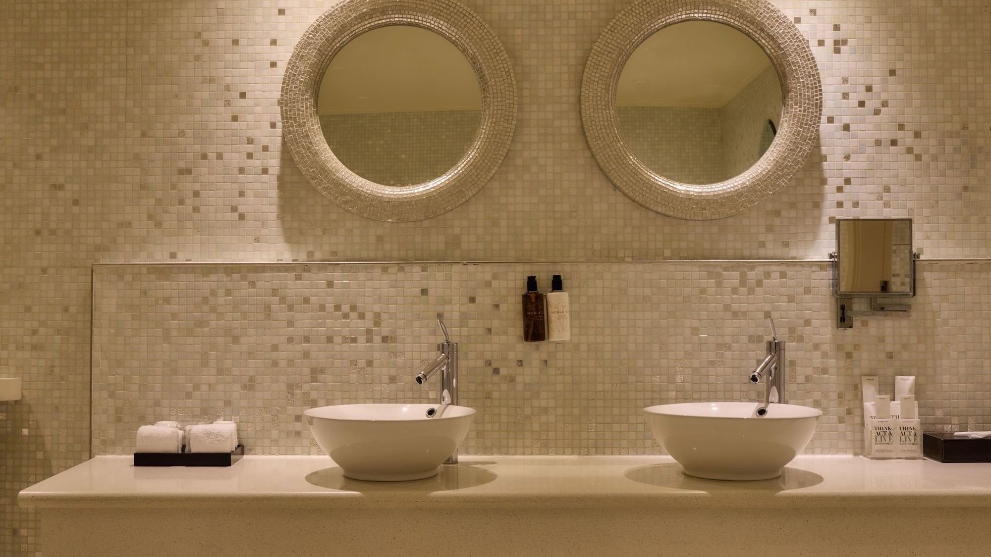 Elegant double vanity with vessel sinks and circular mirrors in The Penthouse Suite at The May Fair Hotel, London.