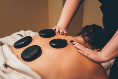 Lady having a hot stone massage in Sun Tree Spa at Temple Gardens Hotel & Spa