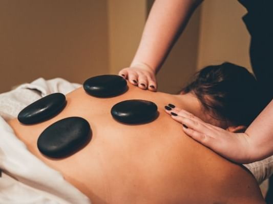 Lady having a hot stone massage in Sun Tree Spa at Temple Gardens Hotel & Spa