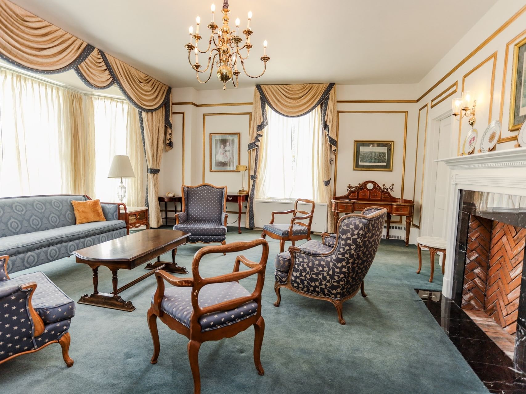 Blue armchairs by a wood coffee table under draped windows in The Presidential lounge at Arlington Resort Hotel & Spa