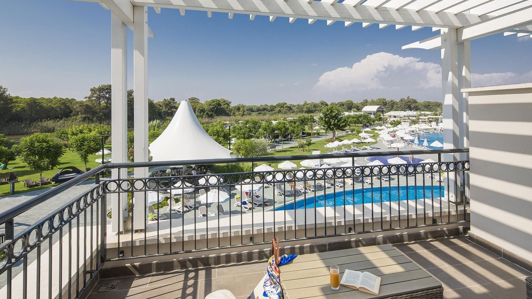 Titanic Deluxe Golf Belek'teki Family Pool Suite Balcony, havuza ve yemyeşil doğaya bakan.