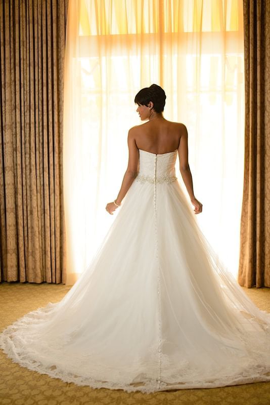 Bride posing by a large curtain at Terra Nova Suite Hotel