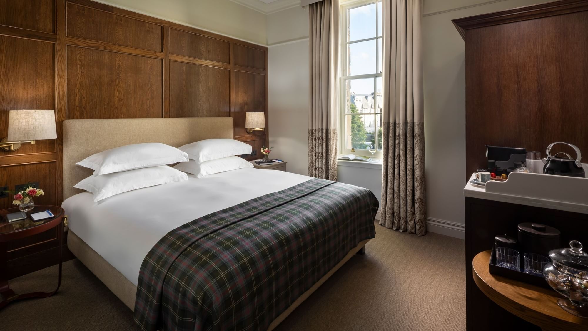 Bed by the window and a coffee station on a wooden cabinet in Deluxe at Seaton House