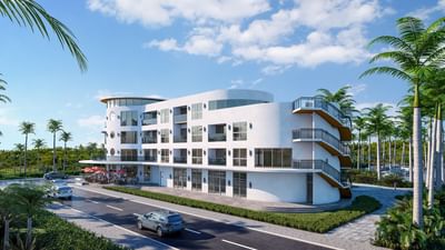 White facade of Ellipse Grace Bay, best hotels in Turks with stairs by a side garden under palm trees and a clear blue sky