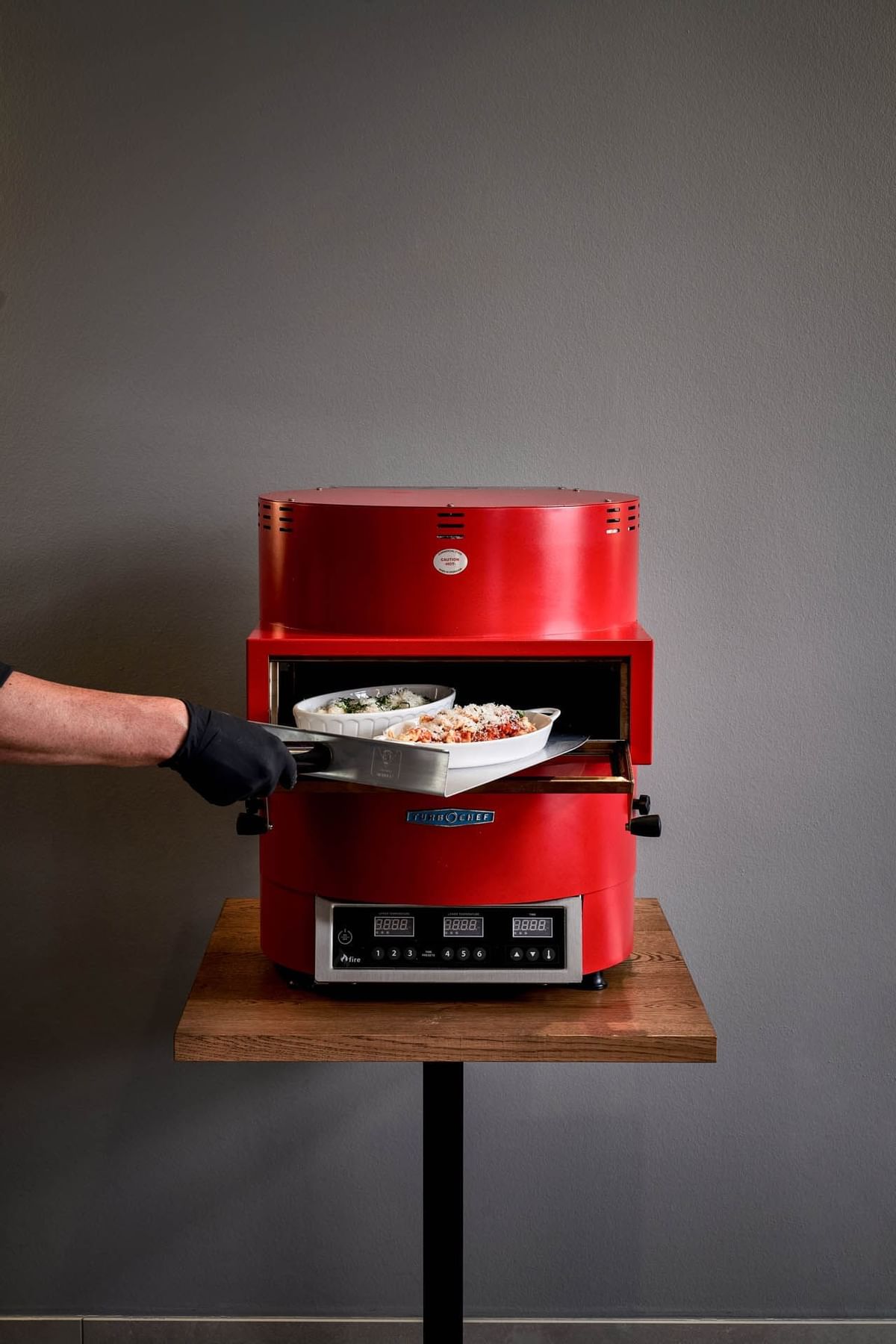 Placing food in oven in Ofen Cucina used at Flemings Munchen