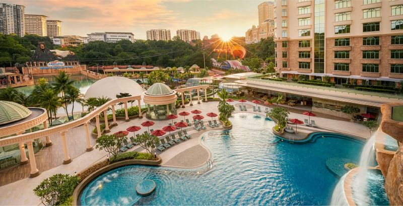 Aerial view of the outdoor pool complex and waterpark near Sunway resort, vibrant sunset in the background