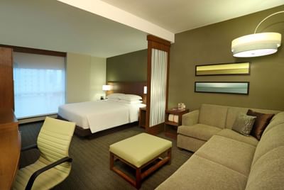 Deluxe King with a bed, sofa, desk and window overlooking a city view at MARlNN Place Financial District