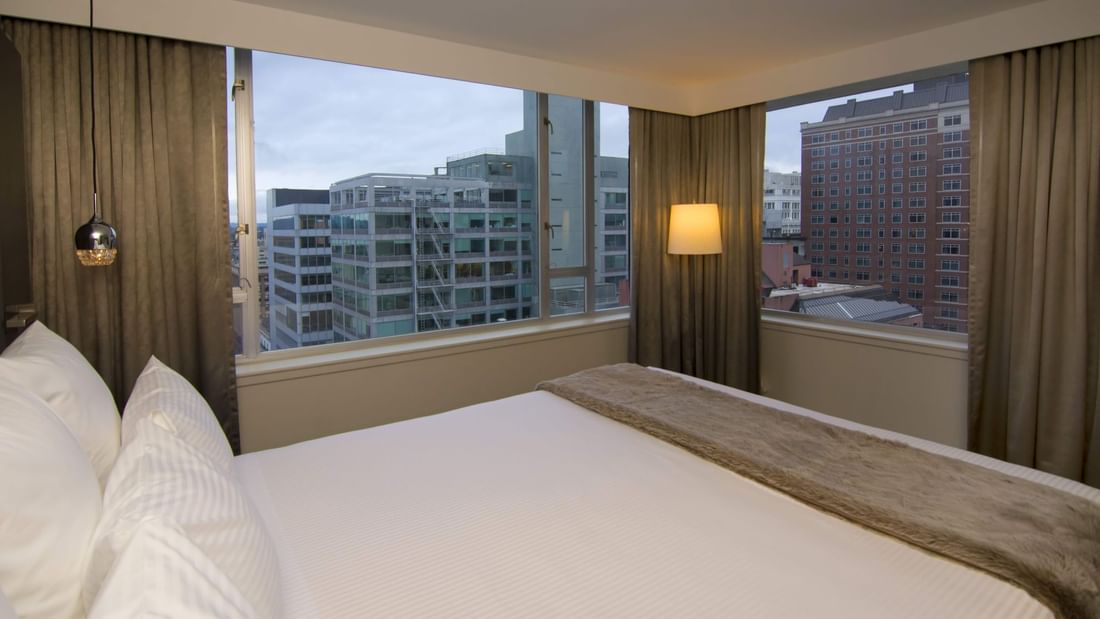 King bed in hotel room with city views