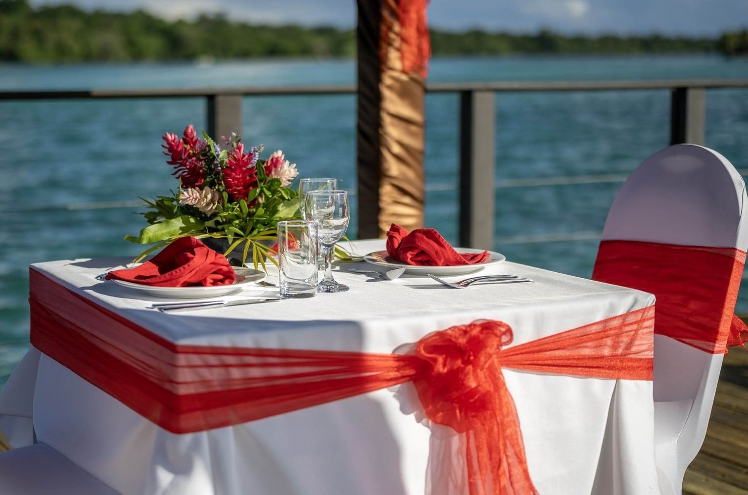 Romantic dining setting with red & white theme, including red napkins & floral centerpiece at warwick le lagon-vanuatu