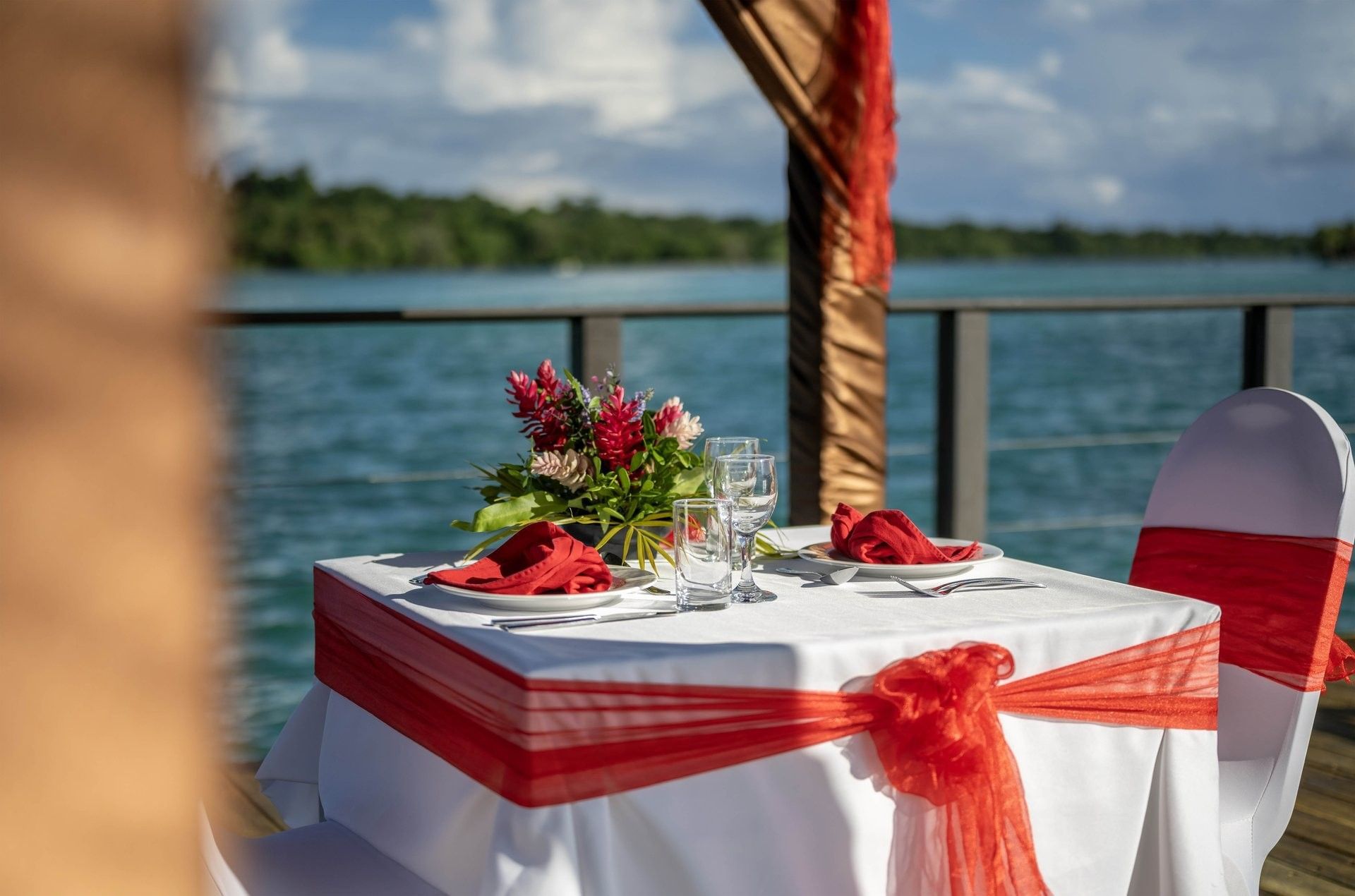 Romantic dining setting with red & white theme, including red napkins & floral centerpiece at warwick le lagon-vanuatu