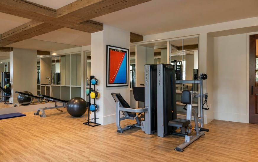 Modern gym at Granduca Houston with exercise equipment and warm wood flooring, part of the upscale hotels in Houston