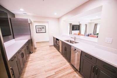 kitchen counter with sink, dishwasher, cabinets, and refrigerato