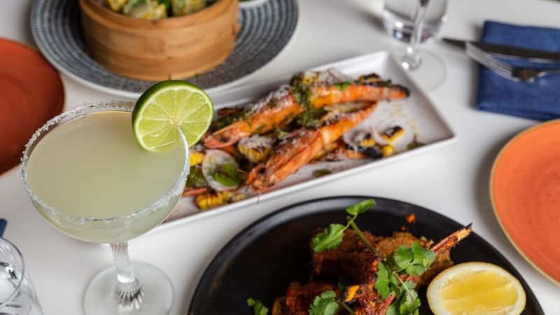 Delicious in-room dining with a margarita, prawns, and other dishes served at Novotel Sydney on Darling Harbour