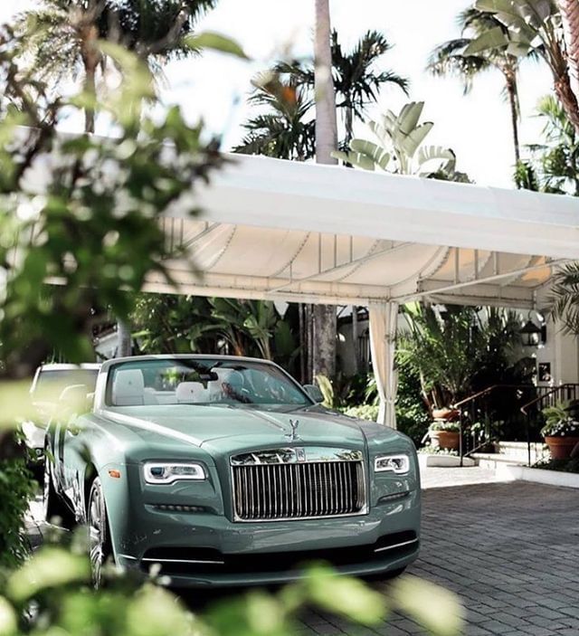 Vintage light green Rolls-Royce Dawn parked under white porte-cochere canvas canopy at The Brazilian Court