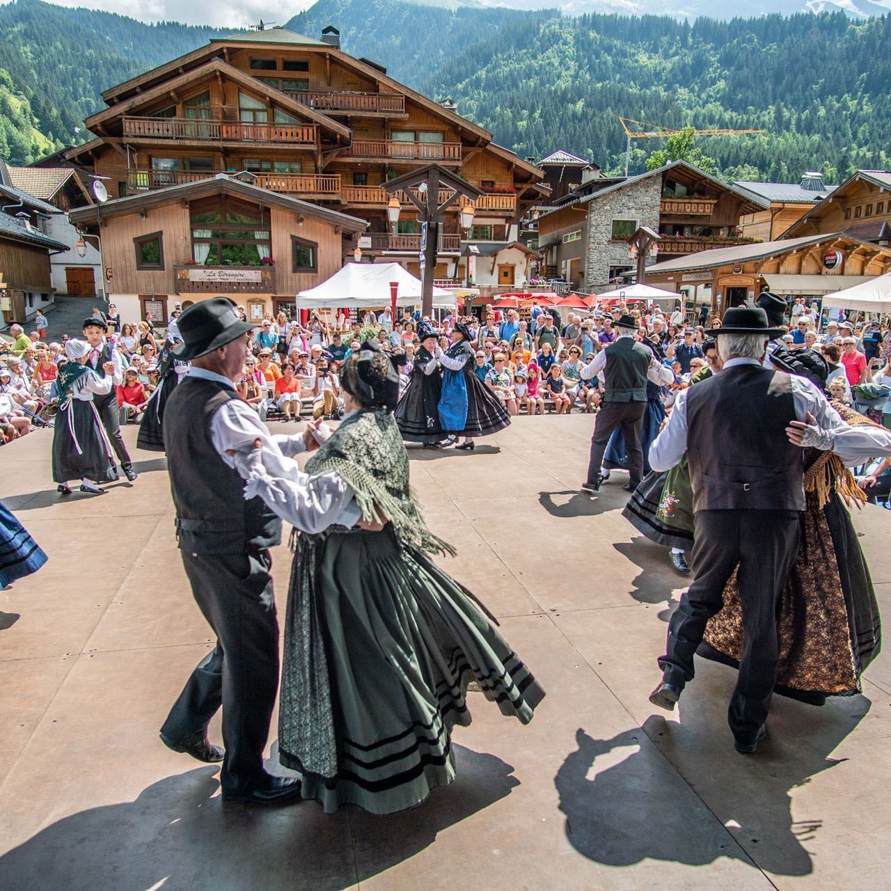 Elderly couples dancing at a village fair near Originals Hotels