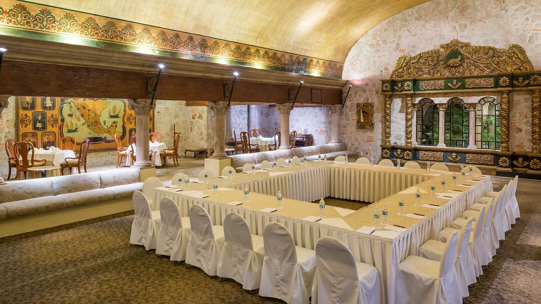 Large square conference table set with white chairs in Salón Los Murales at Quinta Real Aguascalientes