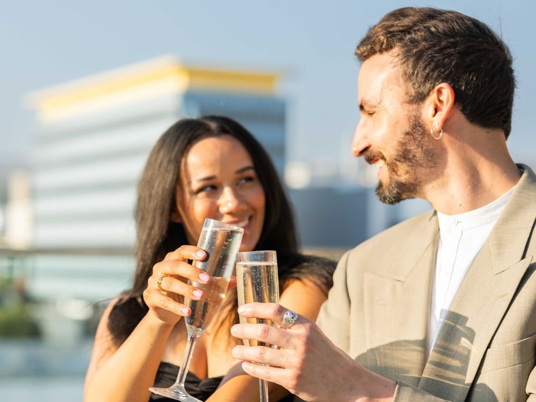 Couple with prosecco in hand cheersing at The Godfrey Hotel Hollywood
