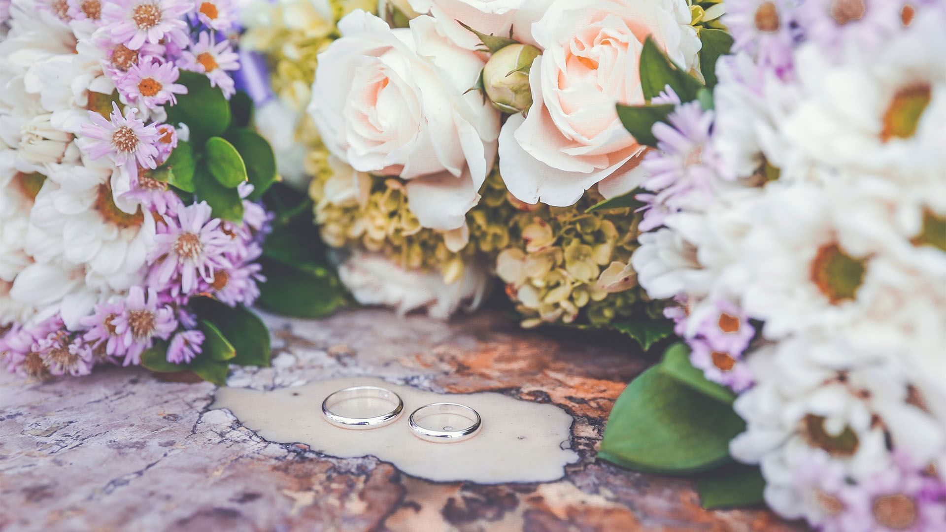 Close-up of wedding bands & flowers at Falkensteiner Schlosshotel Velden