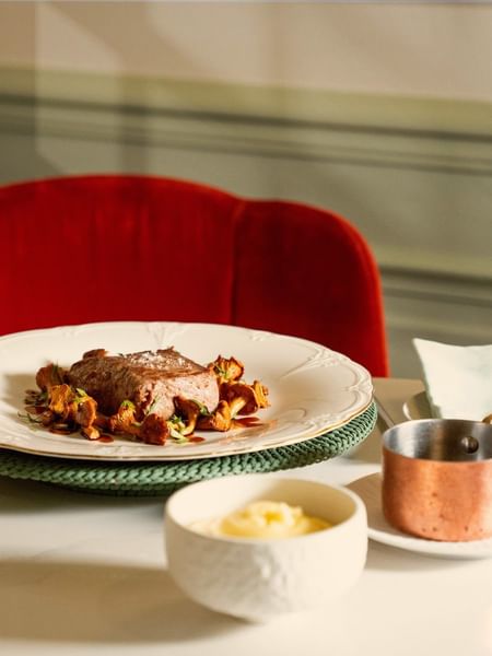 Elegant plated meat dish with red wine and copper saucepan at Le Céladon, Hôtel Westminster - Paris