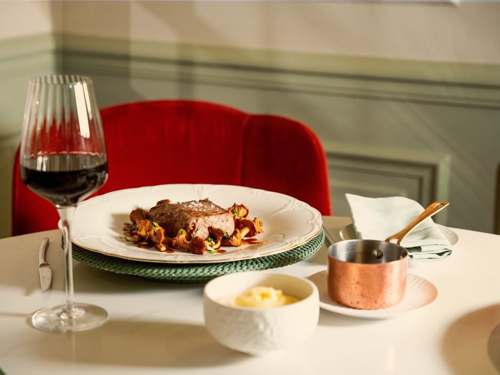 Elegant plated meat dish with red wine and copper saucepan at Le Céladon, Hôtel Westminster - Paris