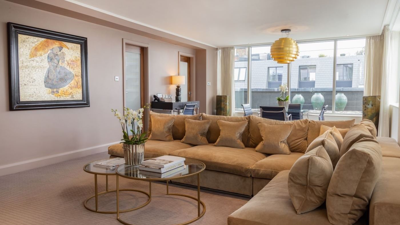 Cozy living room with couch, coffee tables, and art in The Saffron Suite at The May Fair Hotel, London, England.