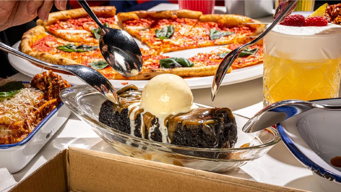 Chocolate dessert with ice cream being shared, alongside pizza at Sunway Lagoon Hotel