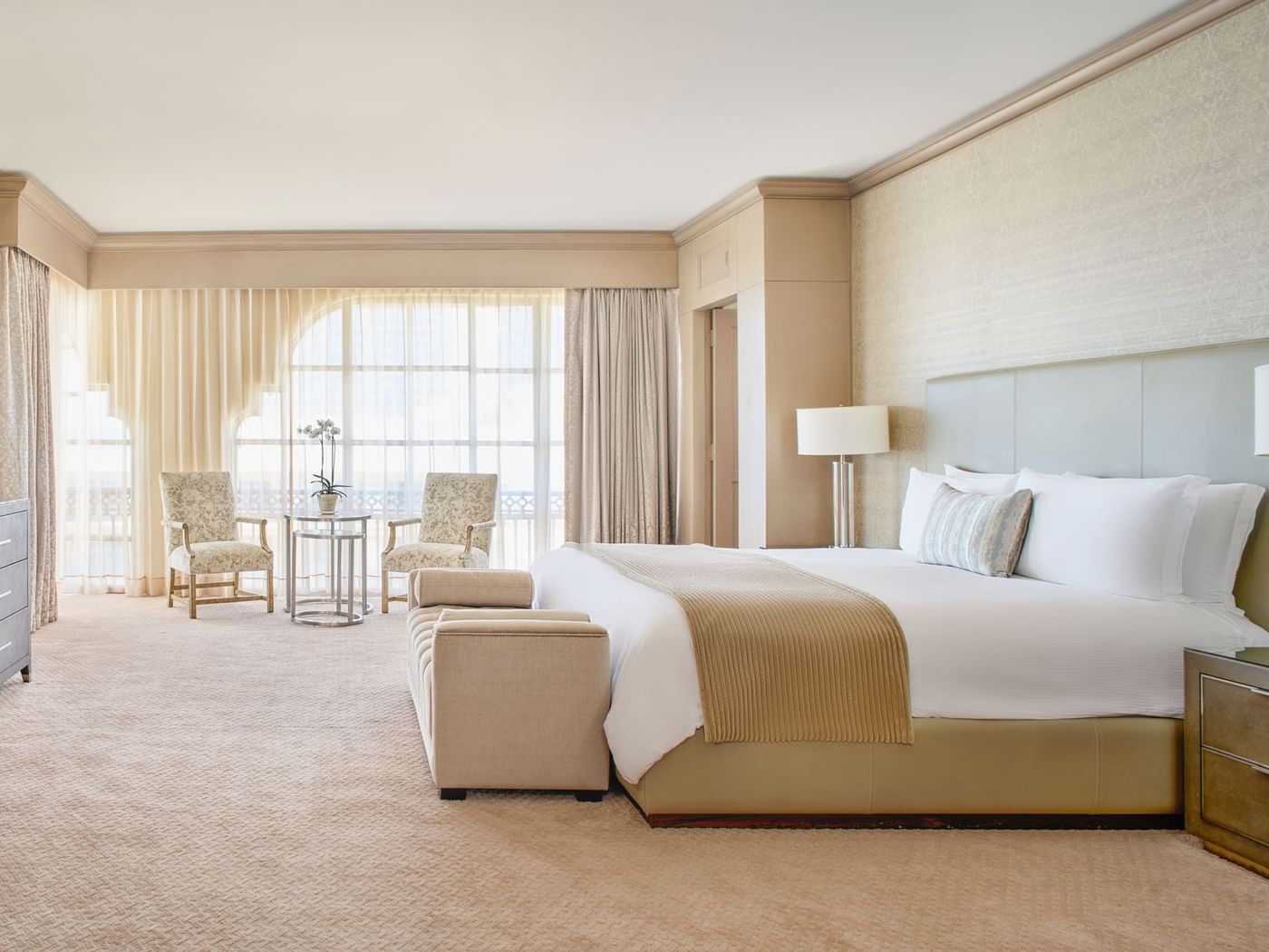 King bed with cozy bench & sitting area in The Presidential Suite at Kempinski Hotel Cancún