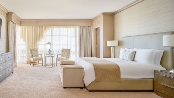 King bed with cozy bench & sitting area in The Presidential Suite at Kempinski Hotel Cancún