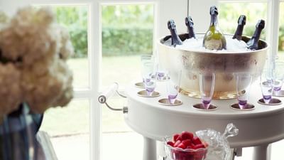 Elegant champagne bucket filled with ice and bottles, surrounded by glasses and fresh strawberries at Park Hyatt Saigon