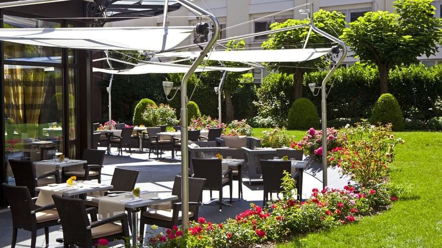 The Lounge Bar & Terrace with wicker chairs and tables, shaded by modern awnings at Warwick Reine Astrid - Lyon