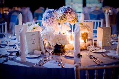Elegant wedding dinner table with floral centerpieces and lit candles at The Saujana Hotel Kuala Lumpur