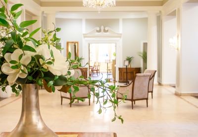 Flowers in a silver vase by plush armchairs in a lobby at Rodd Charlottetown Hotel, perfect for a top-rated hotel in PEI