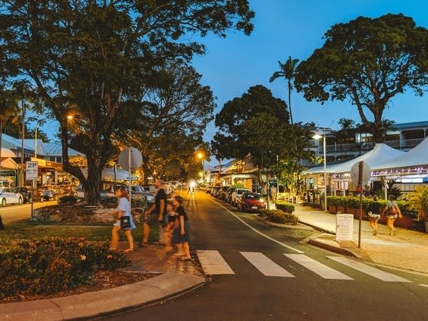 Evening view of Macrossan Street with people walking near Pullman Port Douglas Sea Temple resort & Spa