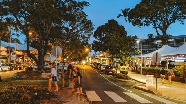 Evening view of Macrossan Street with people walking near Pullman Port Douglas Sea Temple resort & Spa