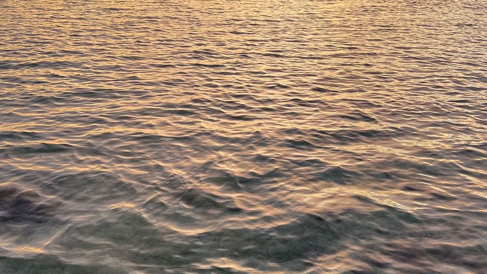 Sunset over the ocean with a tranquil water surface at Warwick Le Lagon - Vanuatu, Efate.