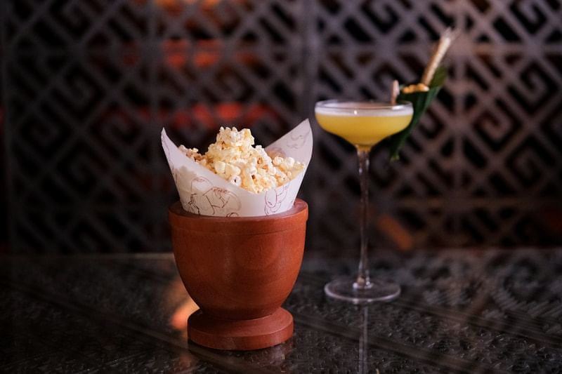 Close-up of a cocktail served with a side of popcorn in 2 Lam Son at Park Hyatt Saigon