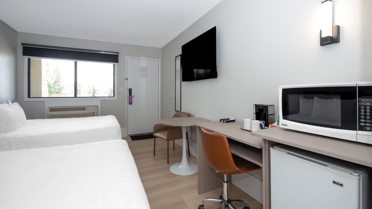 Guest room at Coast Red Deer Hotel with two queen beds, desk and TV