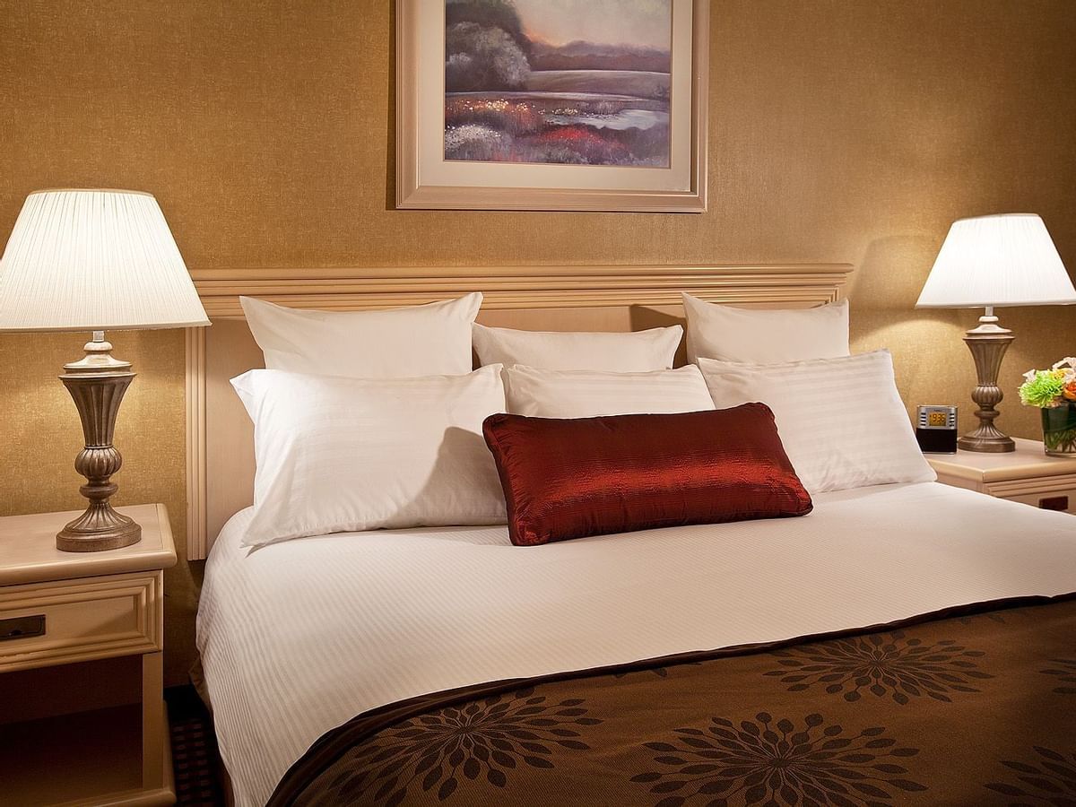 King bed in hotel room with painting above