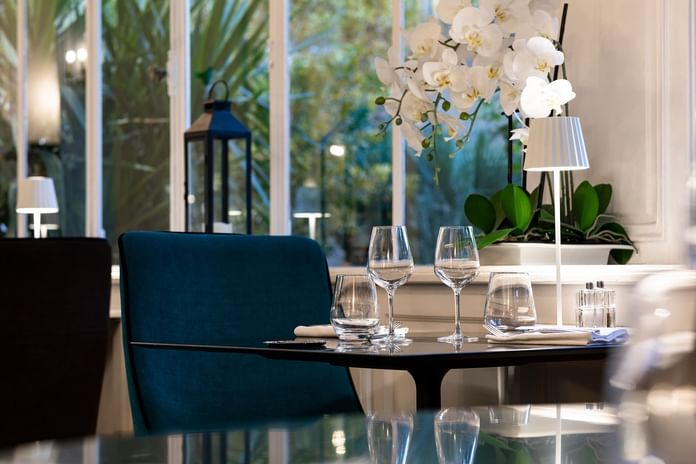 A dining table with glasses & personal light at Oceania Hotels